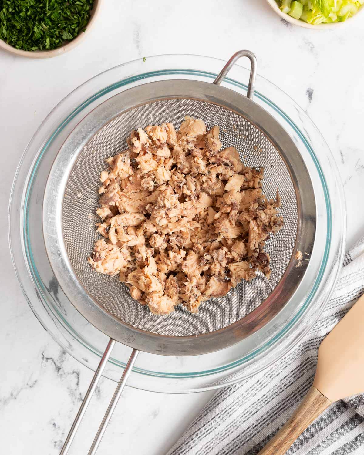 Canned salmon on a mesh strainer.