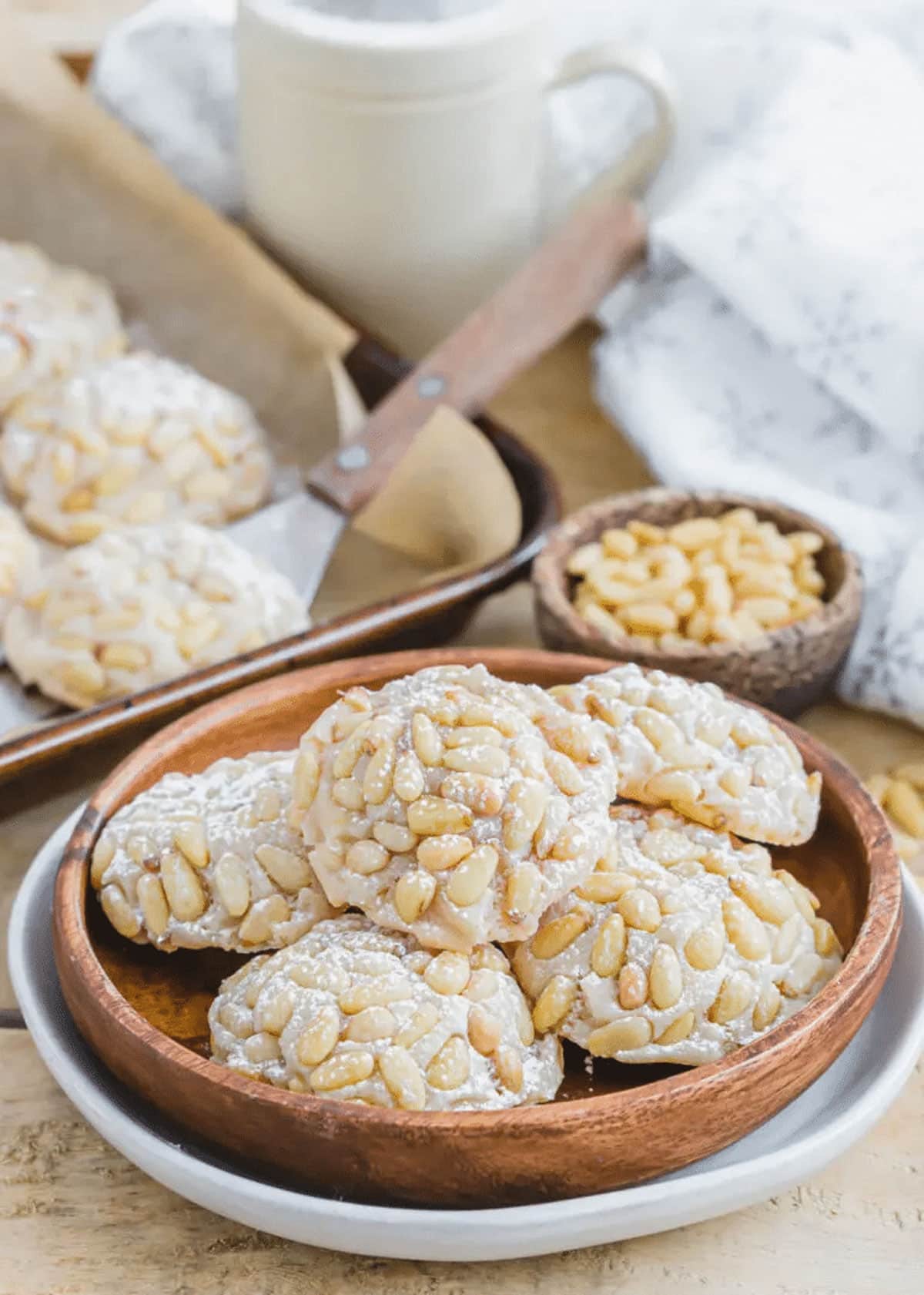 Pignoli cookies in a wooden bowl.