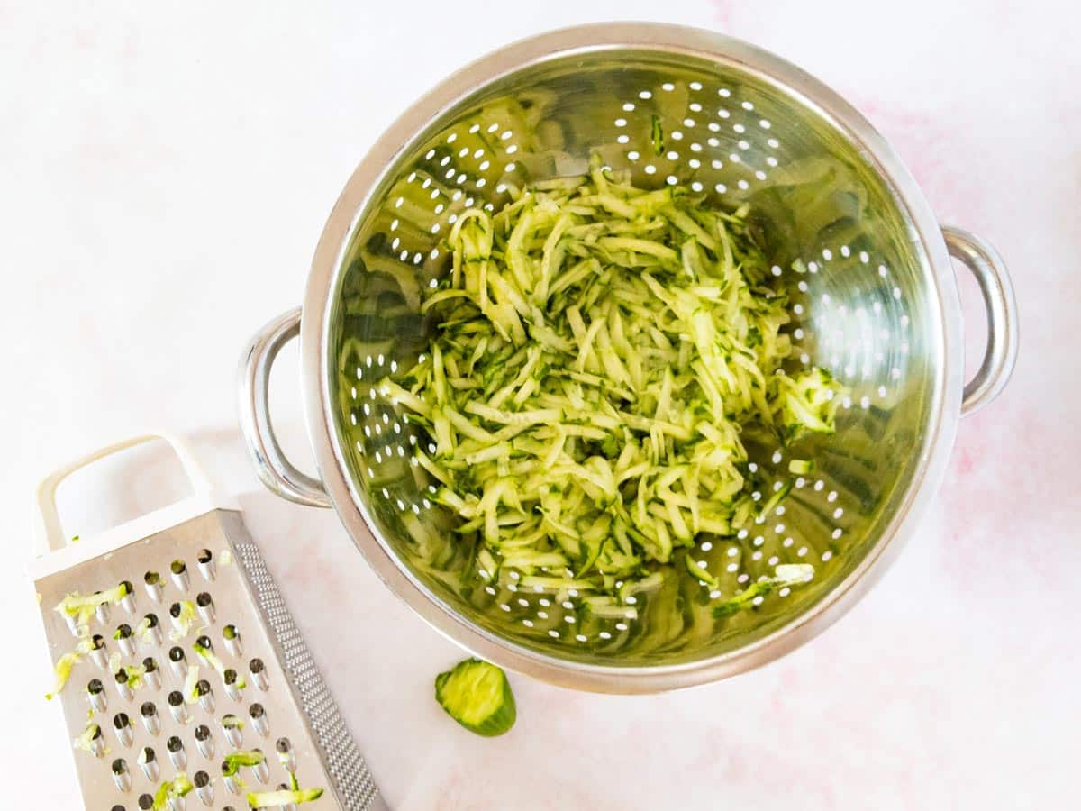 Grated cucumber straining in a colander. 