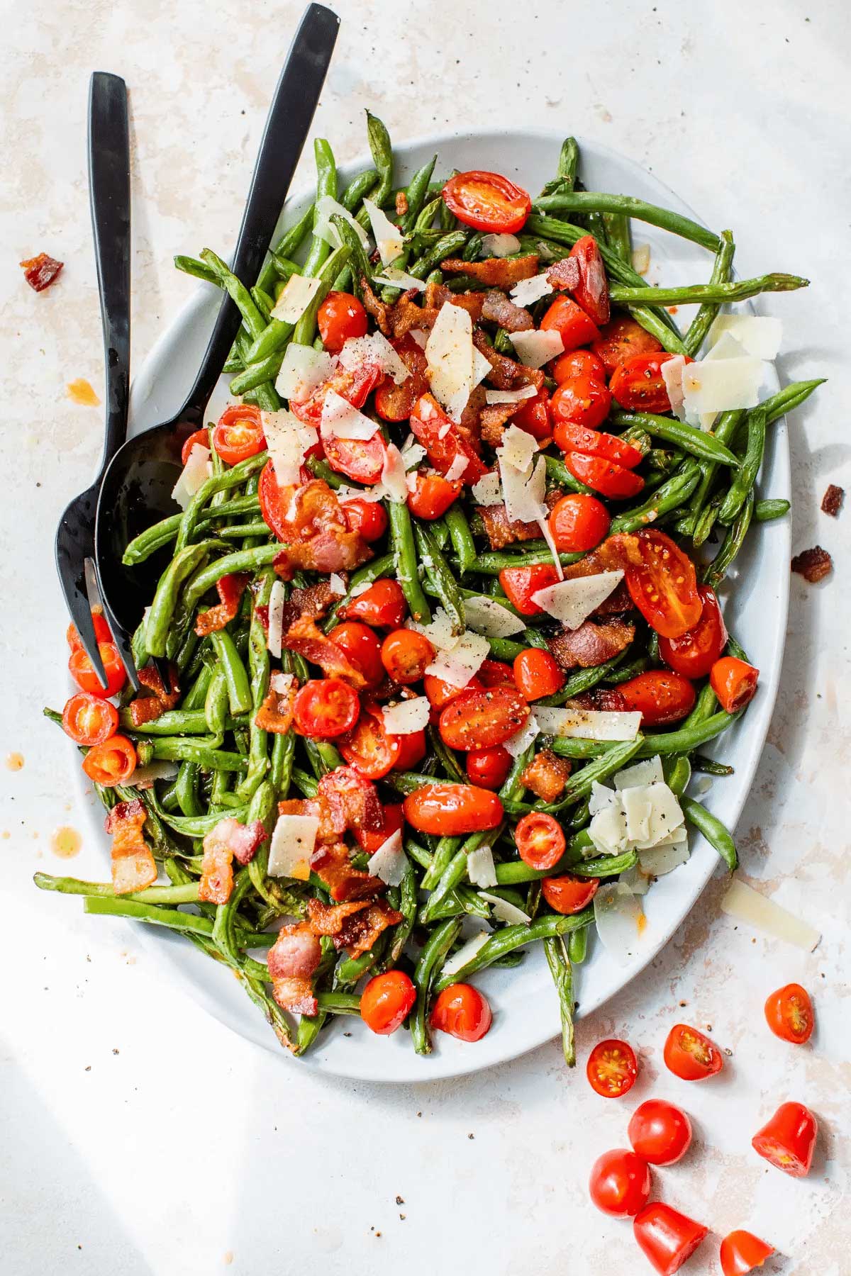 Tomato bacon green bean salad with serving spoon and fork.
