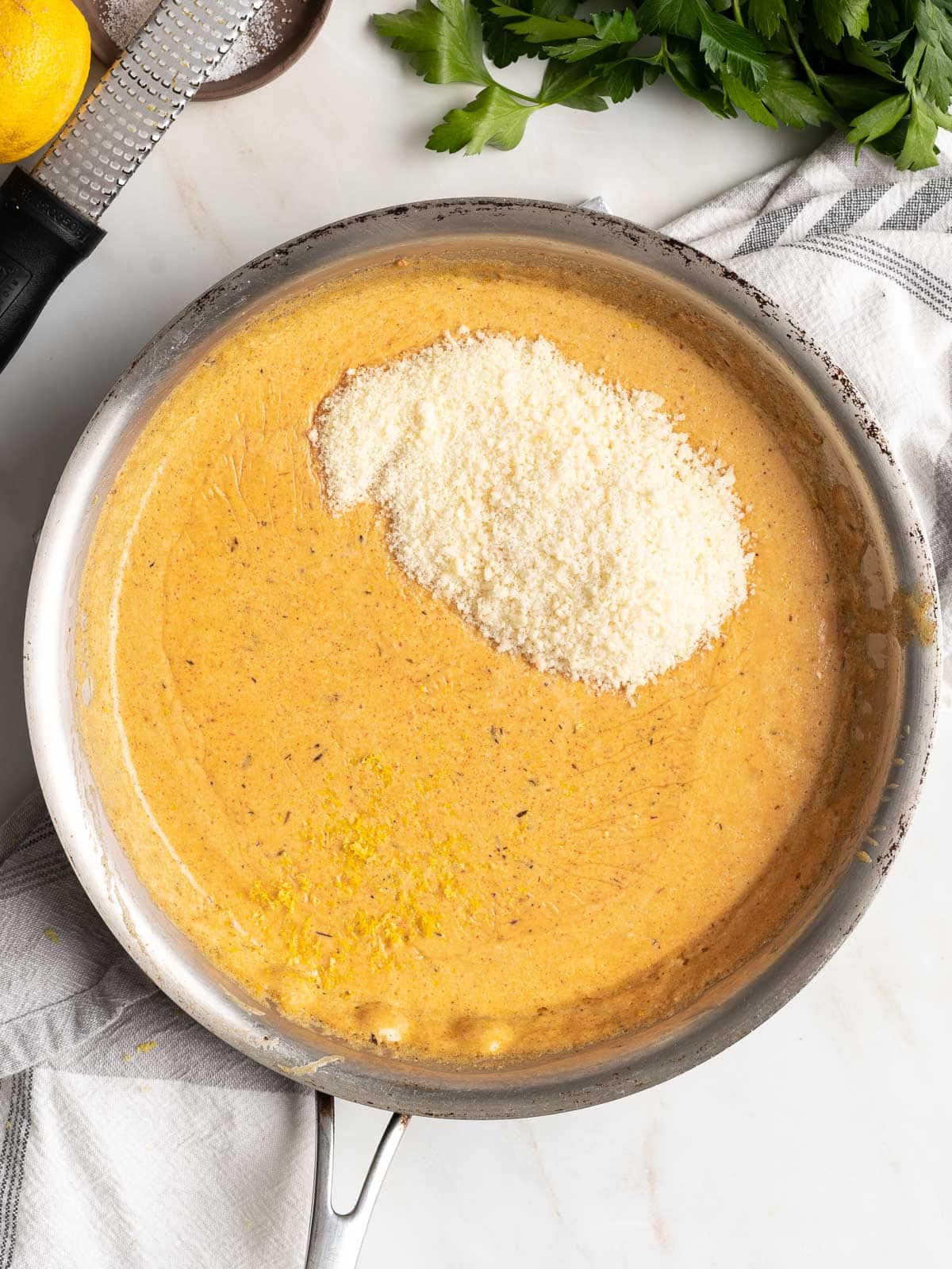 Adding parmesan cheese and lemon zest to the sauce.