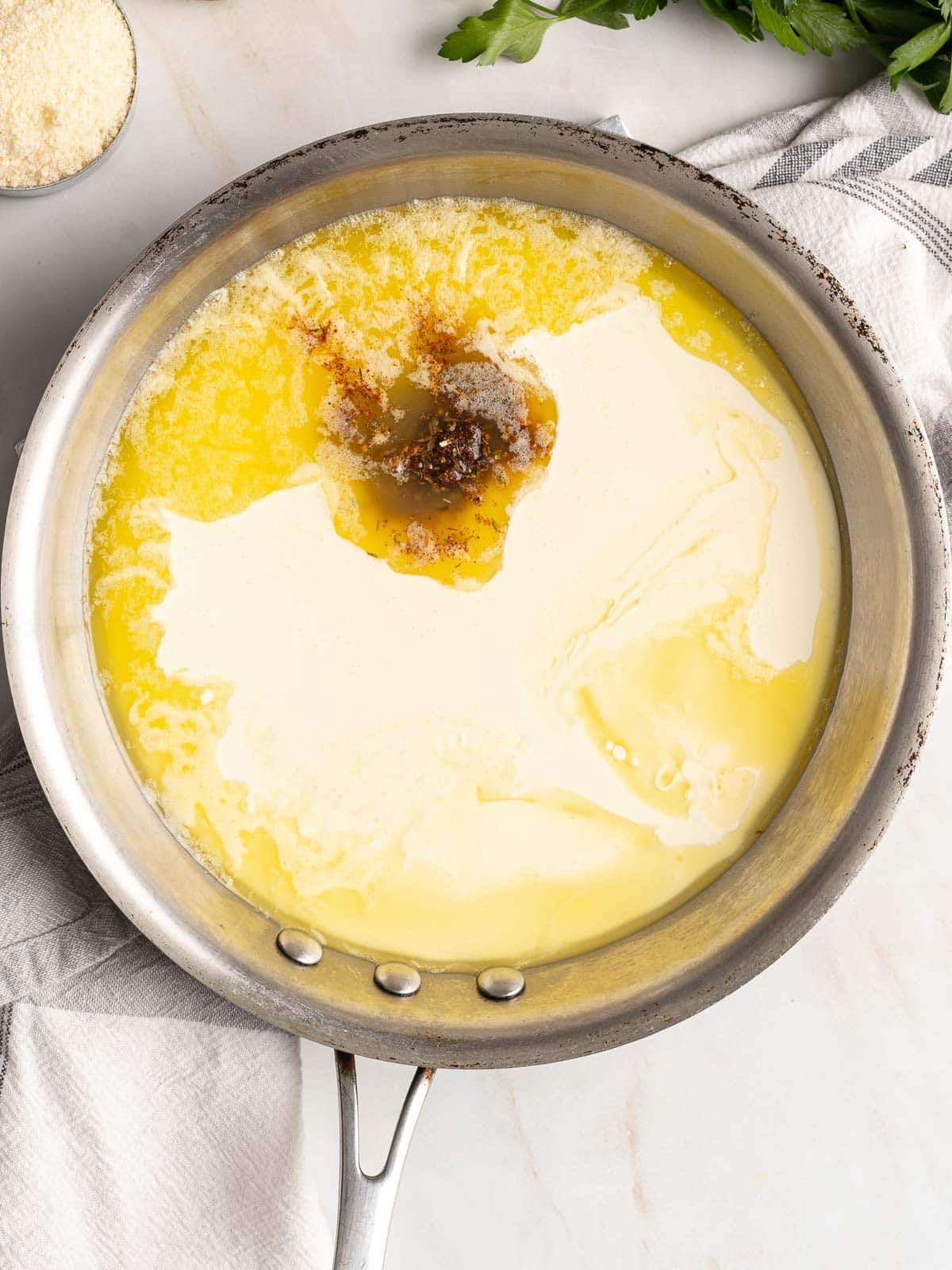 Adding cajun seasoning and cream to the butter.