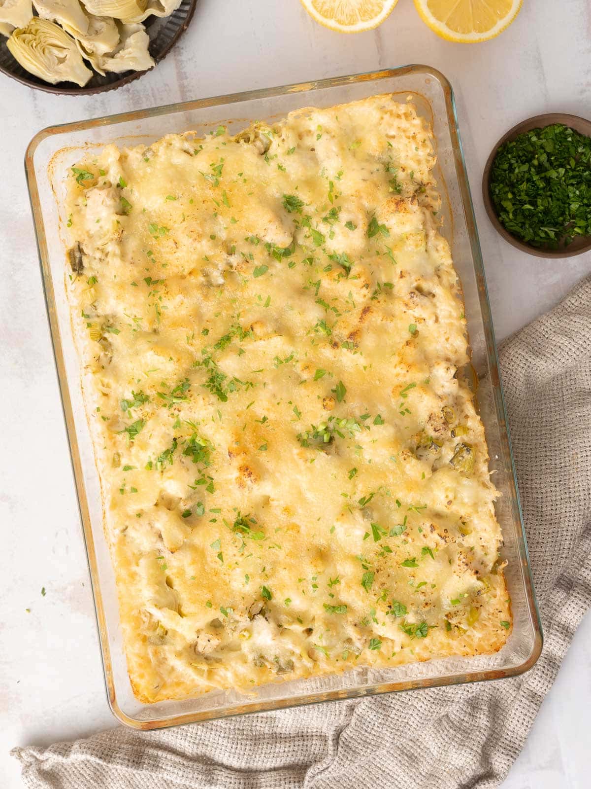 Freshly baked artichoke chicken served in a baking dish.⁣ ⁣