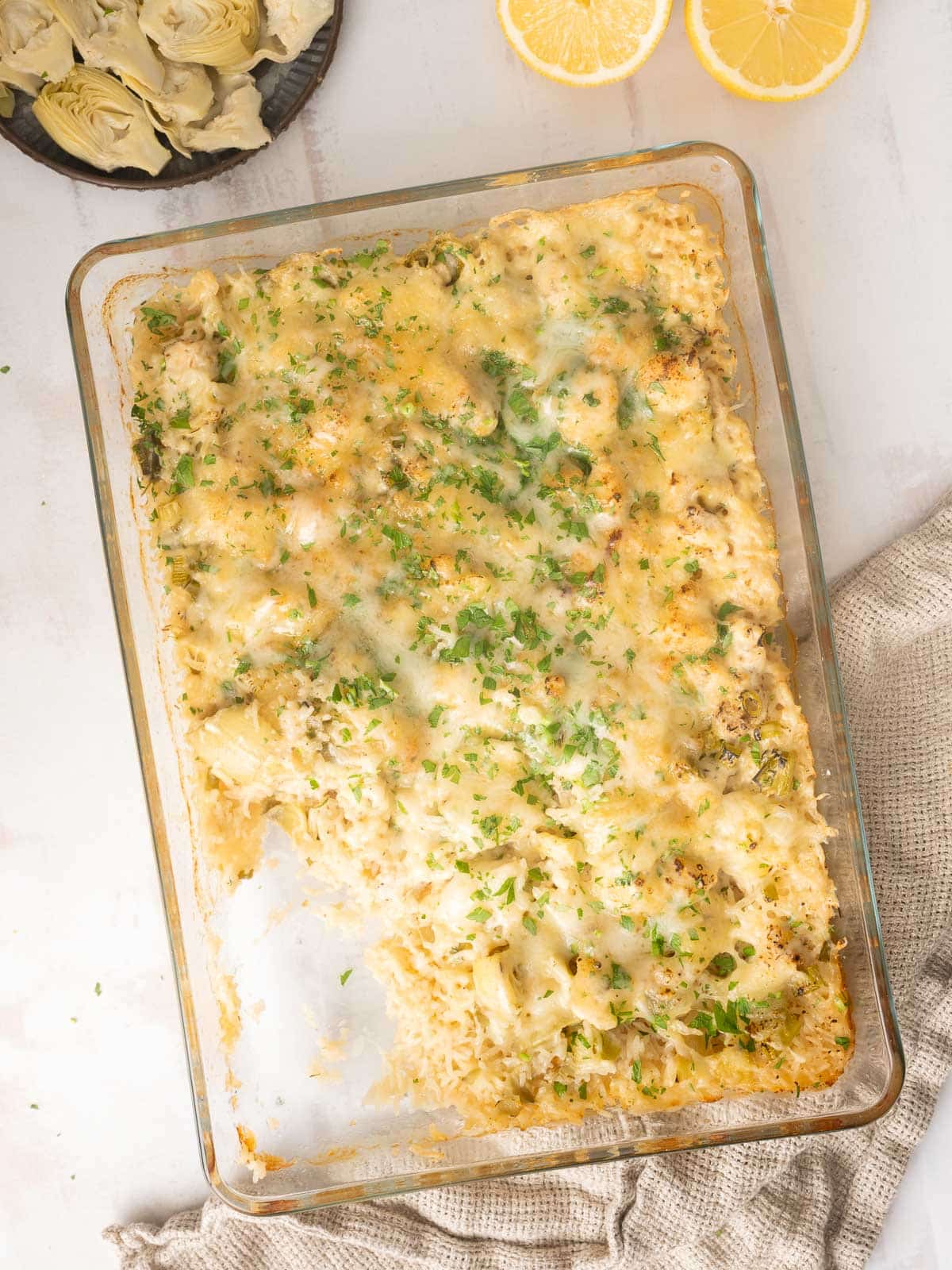 Freshly baked artichoke chicken served in a baking dish.⁣⁣
