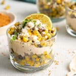 Mexican corn in a cup with a lime wedge.