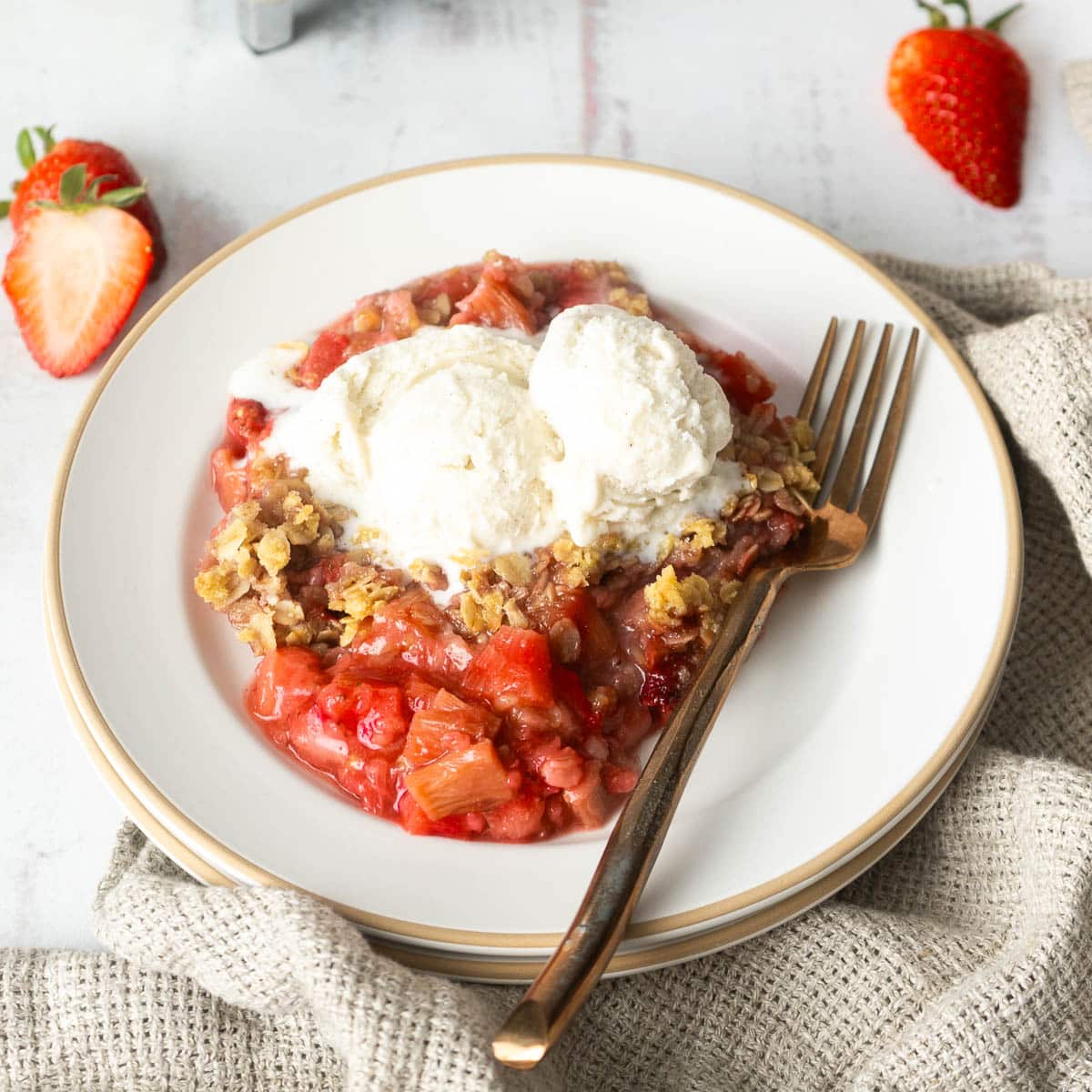 Strawberry crisp on a white plate with a fork.