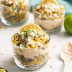 Mexican corn cups with lime wedges.