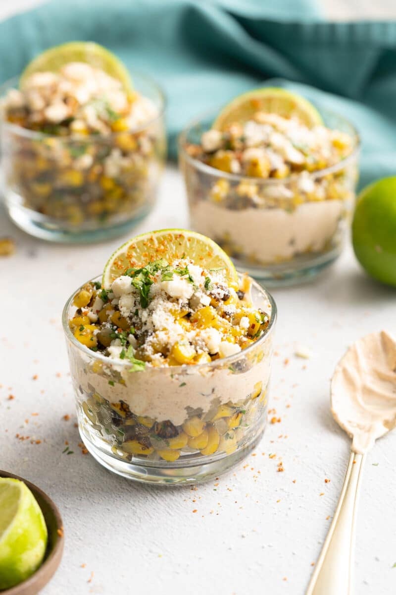 Mexican corn cups with lime wedges.