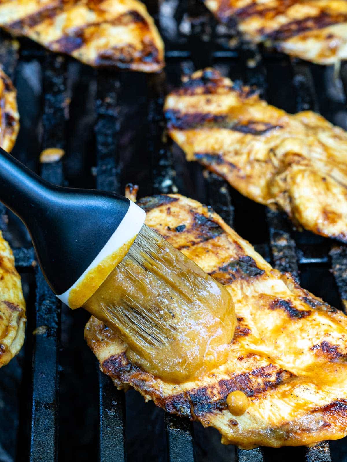 A Carolina BBQ is being grilled brushed with spicy mustard sauce.