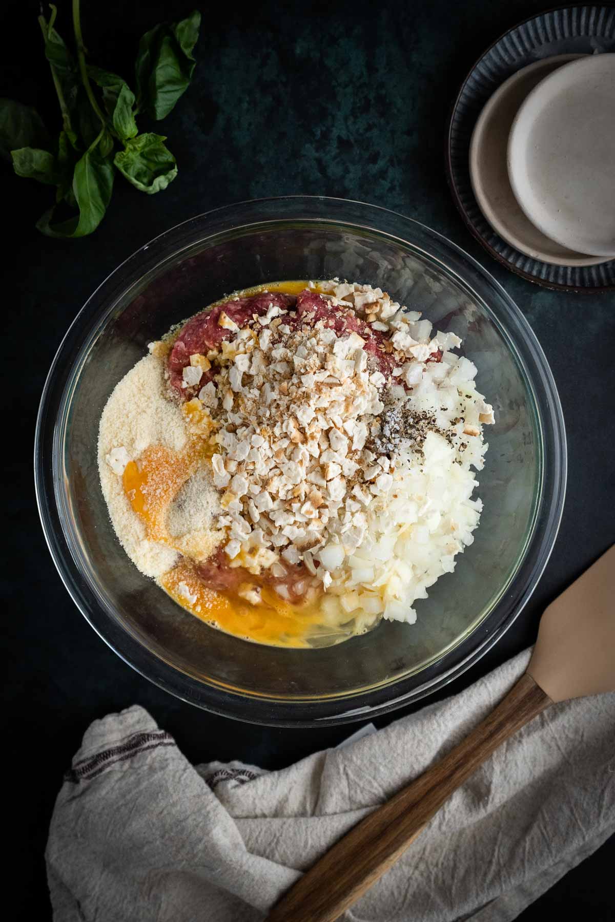 A mixture of Italian meatballs in the mixing bowls resting on the countertop.