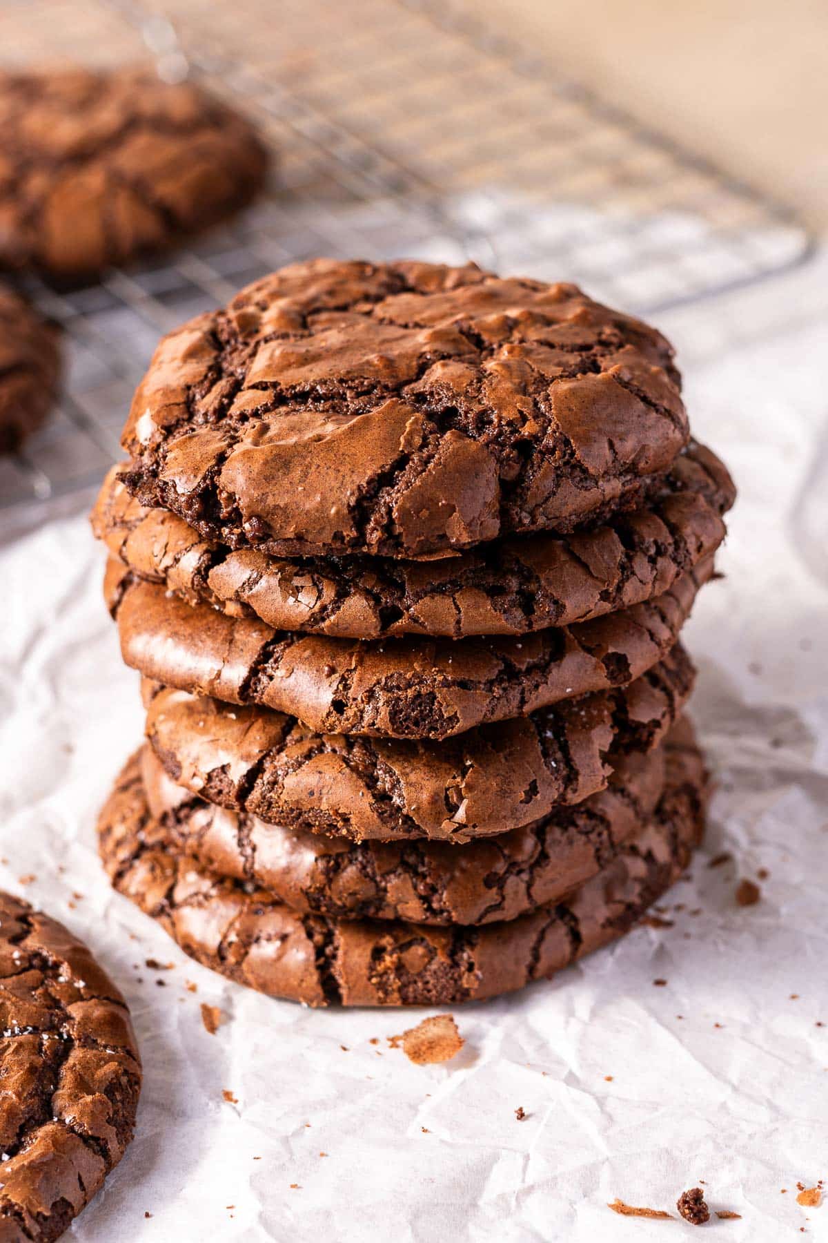 Stack of chocolate brownie cookies on top of a wax paper resting on the table.