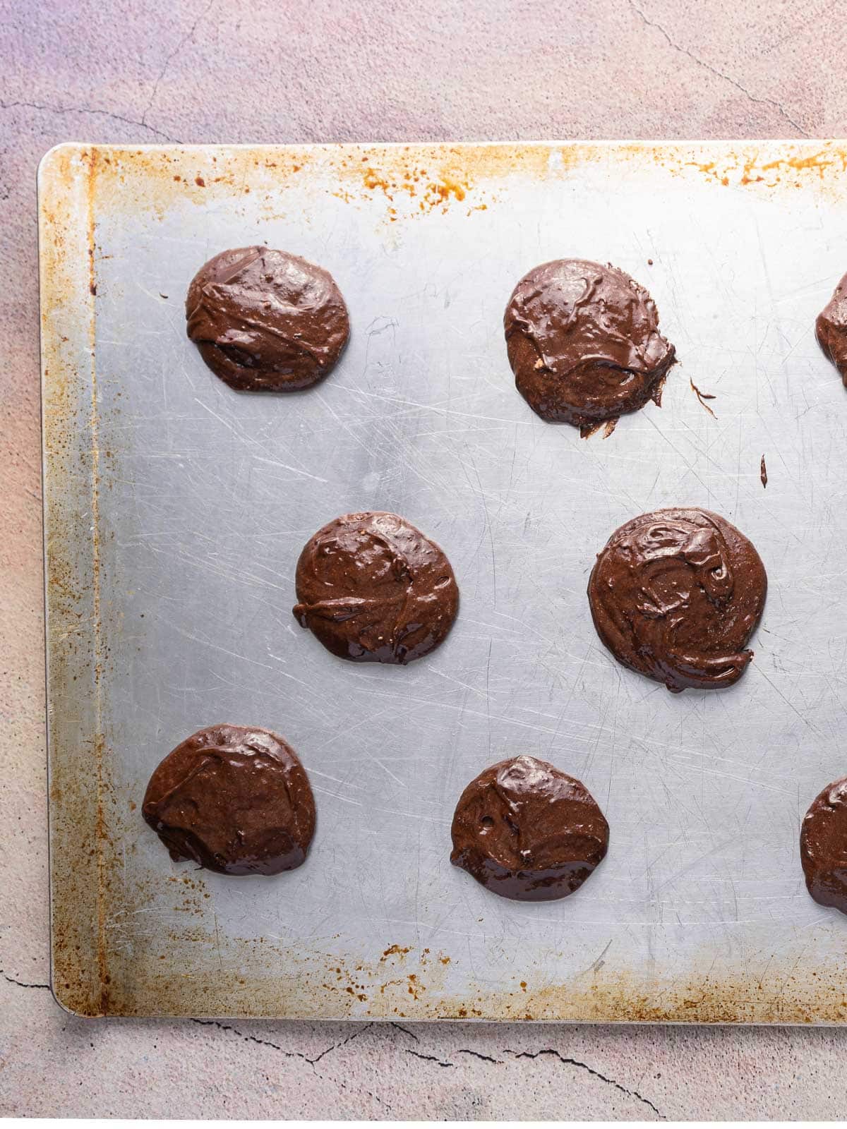 Chocolate ganache spread evenly on a sheet of pastry dough.⁣ ⁣⁣