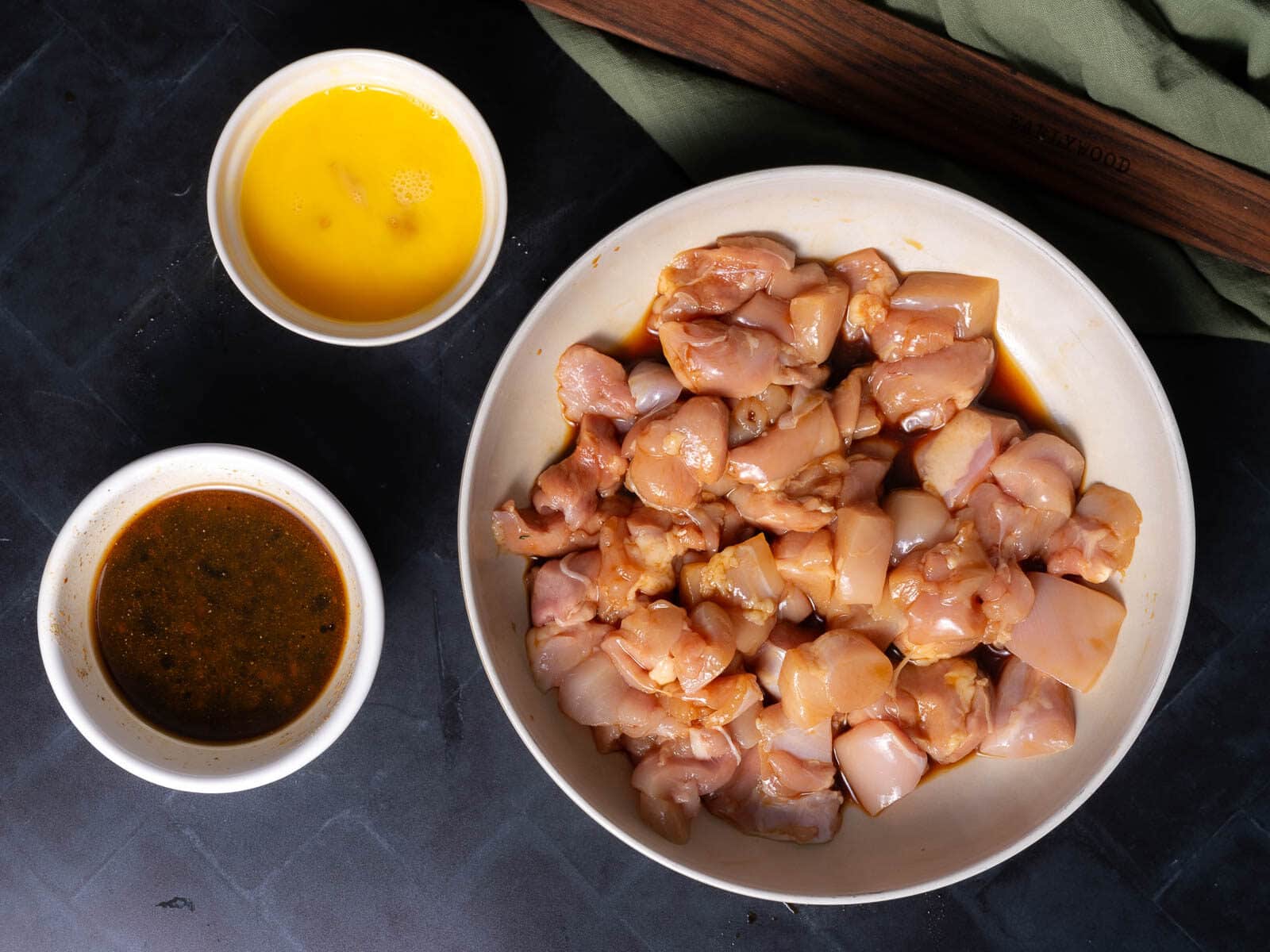 Marinated Chicken and sauces on the countertop.