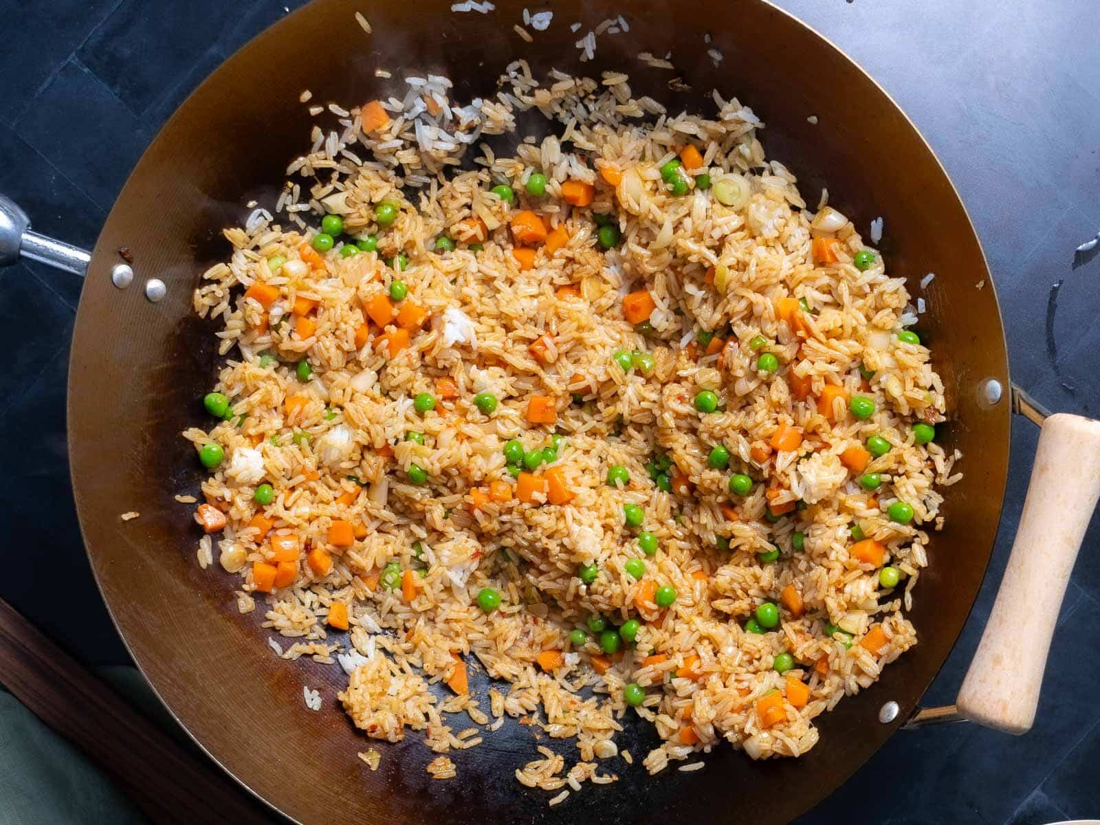 Cooked shrimp fried rice in a wok placed on the countertop.