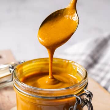 Carolina barbeque sauce dripping from the spoon filling up the jar.