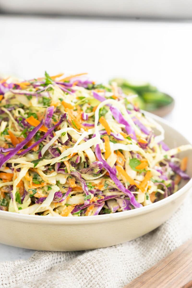 Avocado coleslaw in a salad bowl resting on the table.