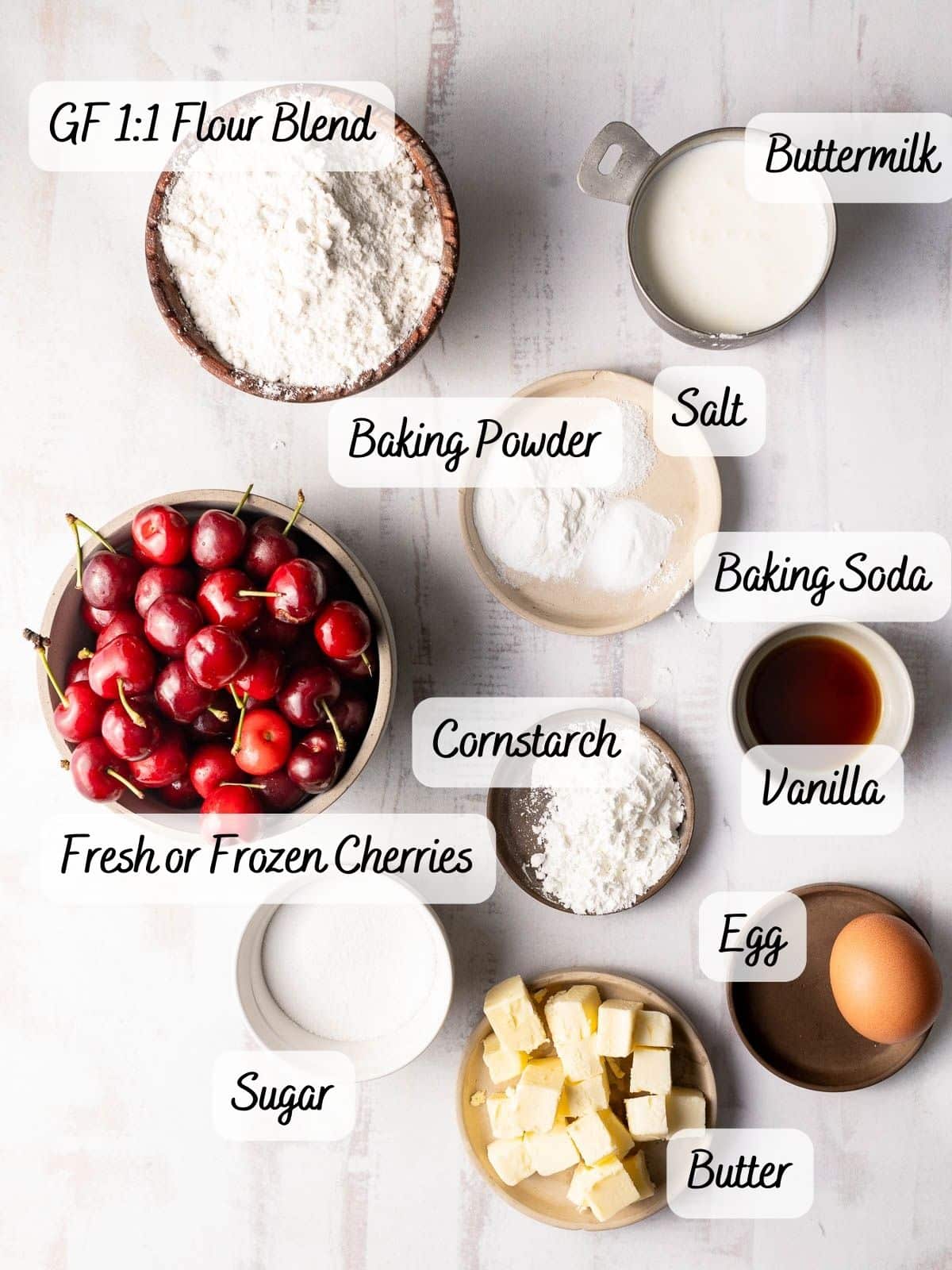 Essential ingredients for cherry cobbler are neatly arranged on the countertop.