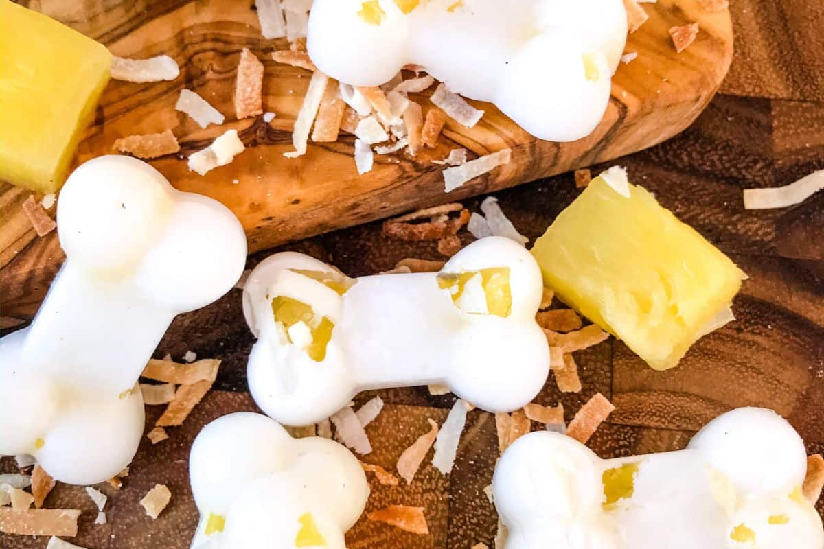 Frozen Pina Colada Dog Treats scattered in a cutting board atop the countertop.