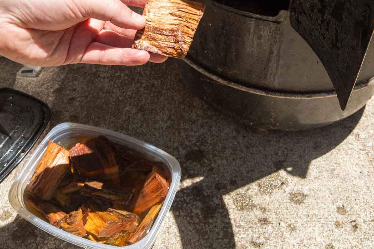 Soaking the wood in water before adding to the smoker. 