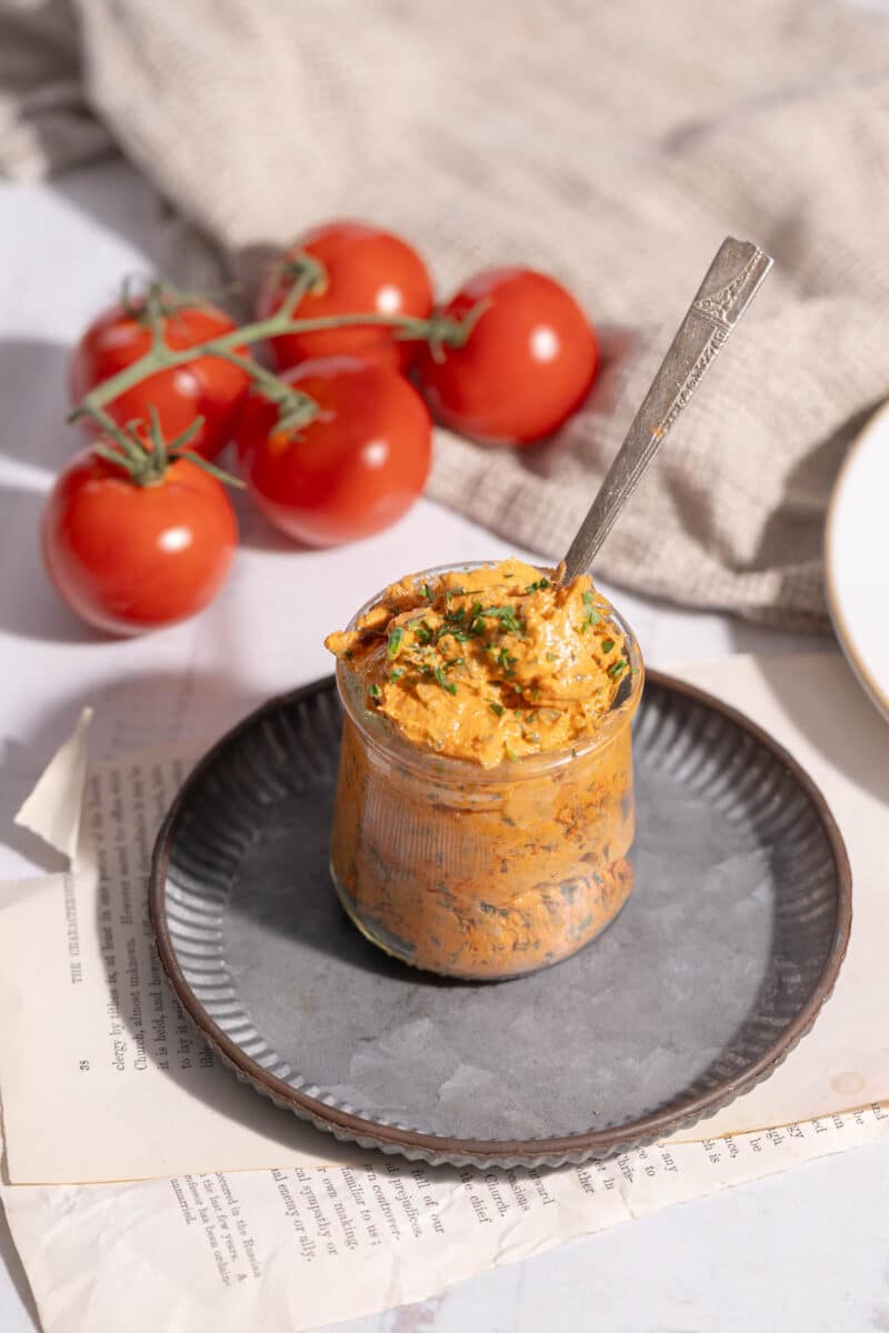 Tomato Butter in a glass over a platter resting on the table.