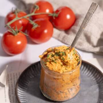Close-up shot of Tomato Butter in a glass over a platter resting on the table.