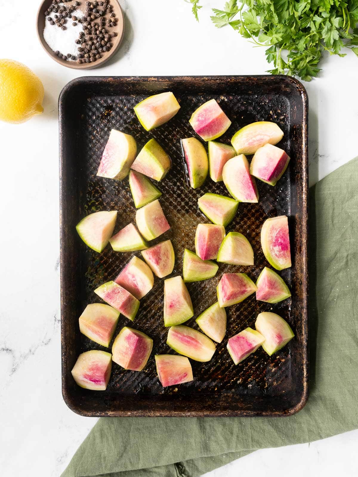 watermelon radishes on a sheet pan before roasting.