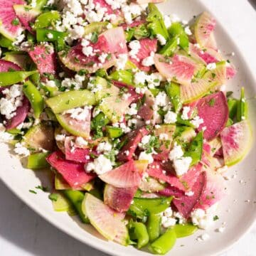 A close-up capture showcasing a watermelon radish salad elegantly served on a platter, impeccably placed on the table.