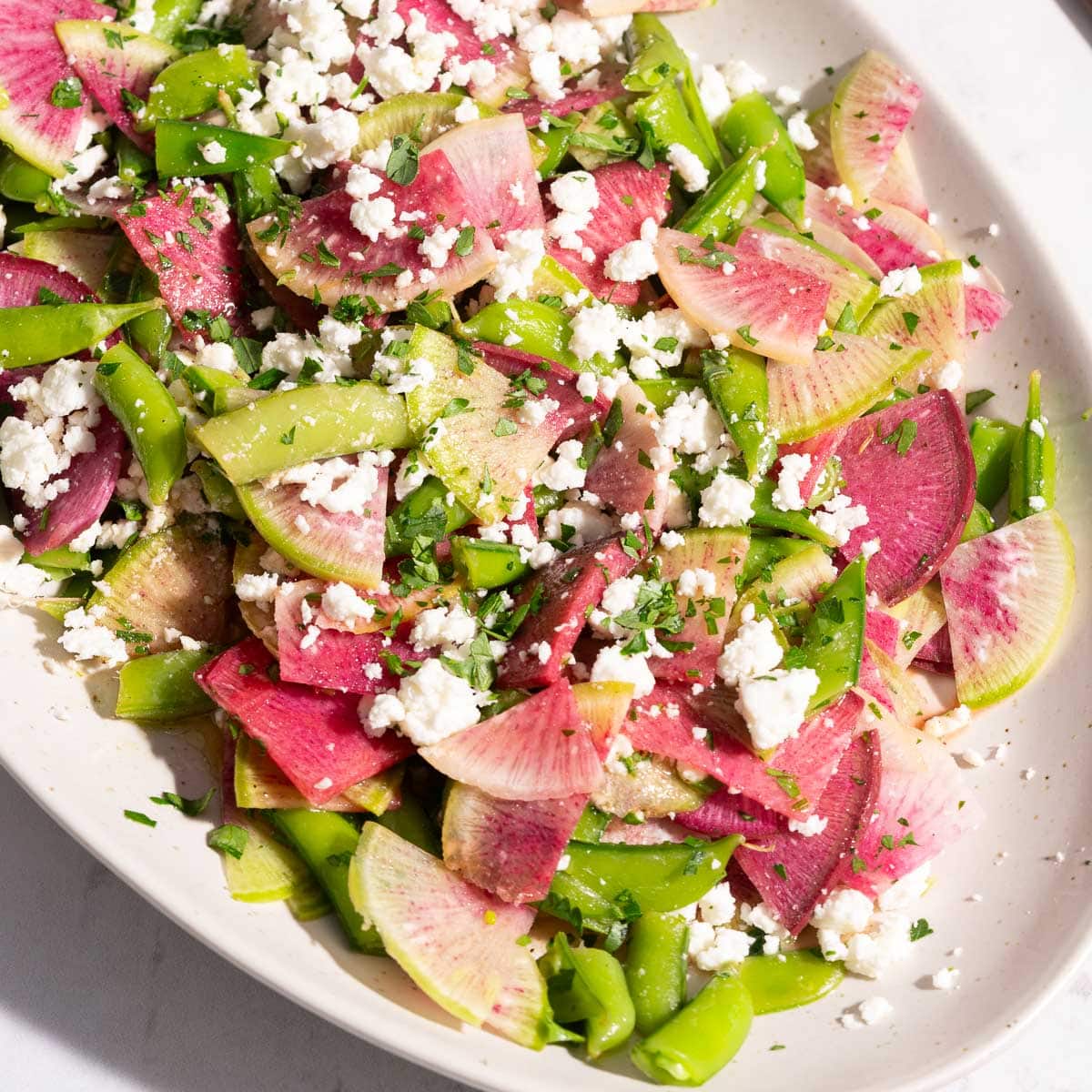 A close-up capture showcasing a watermelon radish salad elegantly served on a platter, impeccably placed on the table.