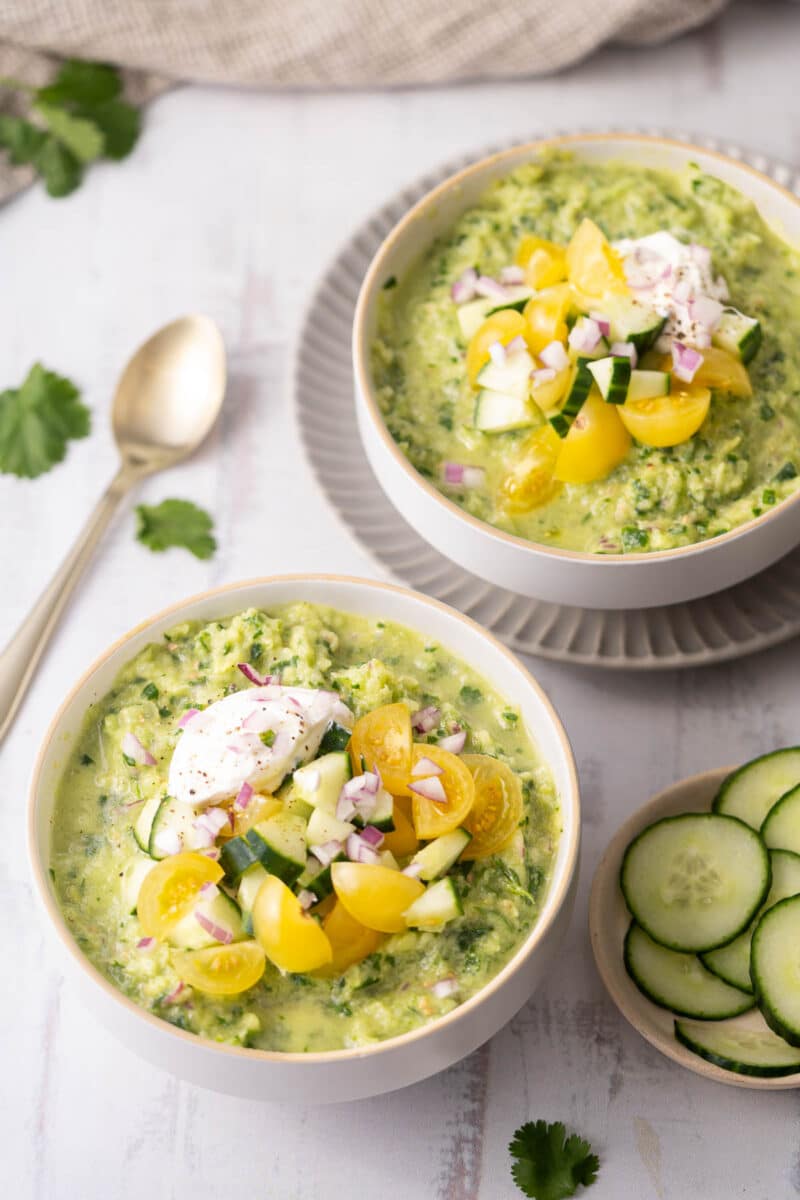 Cucumber Gazpacho served in a bowl topped with a cream.