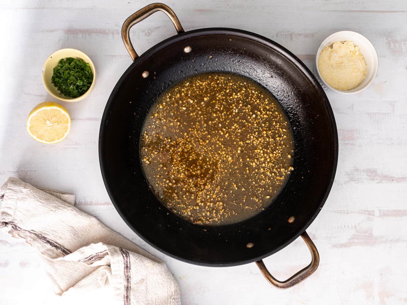 Minced garlic and melted butter in a wok.