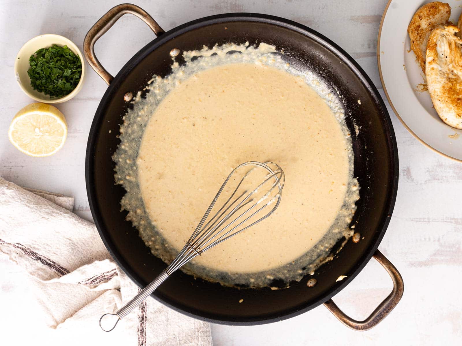 Mixing cream and garlic and parmesan in a wok.
