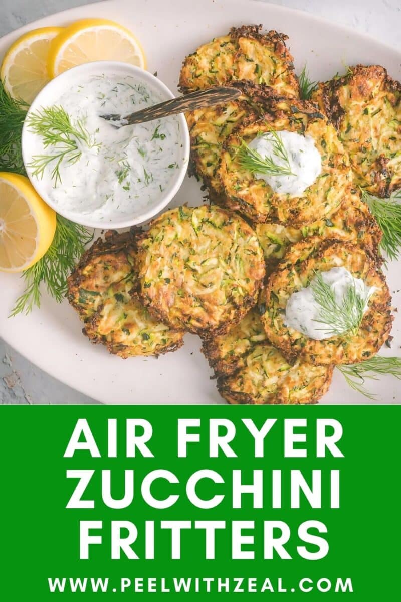 A batch of Zucchini fritters served on an oval shape platter with dill sauce.