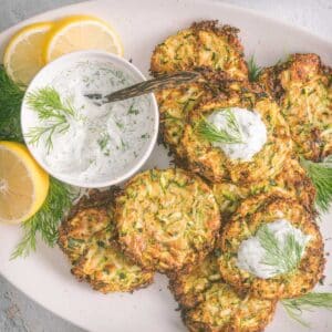 A close-up shot of Zucchini fritters served on a white platter.