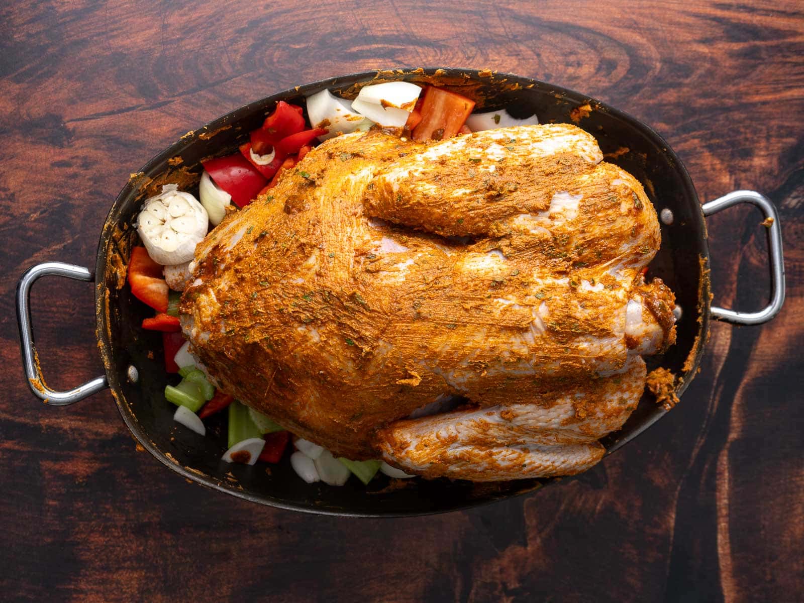 A whole Turkey is being seasoned ready to baked.