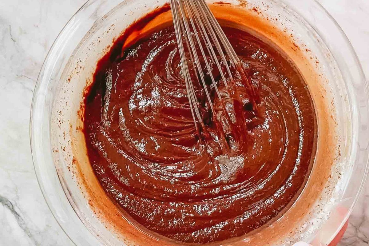 Chocolate batter and whisk in a mixing bowl.