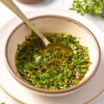 Traditional Chimichurri in a bowl with a spoon.