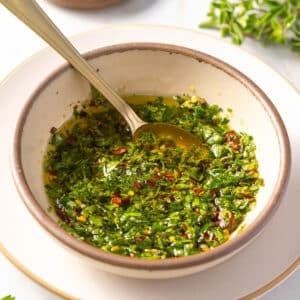 Traditional Chimichurri in a bowl with a spoon.