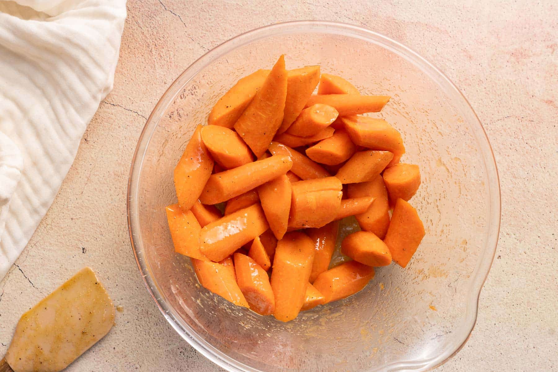 Slices of Carrots seasoned in a mixing bowl.