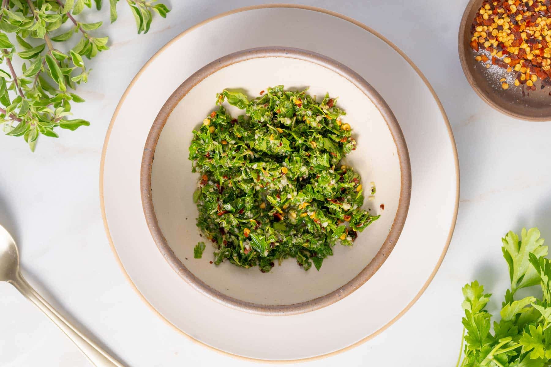 Minced fresh herbs and garlic in a bowl.