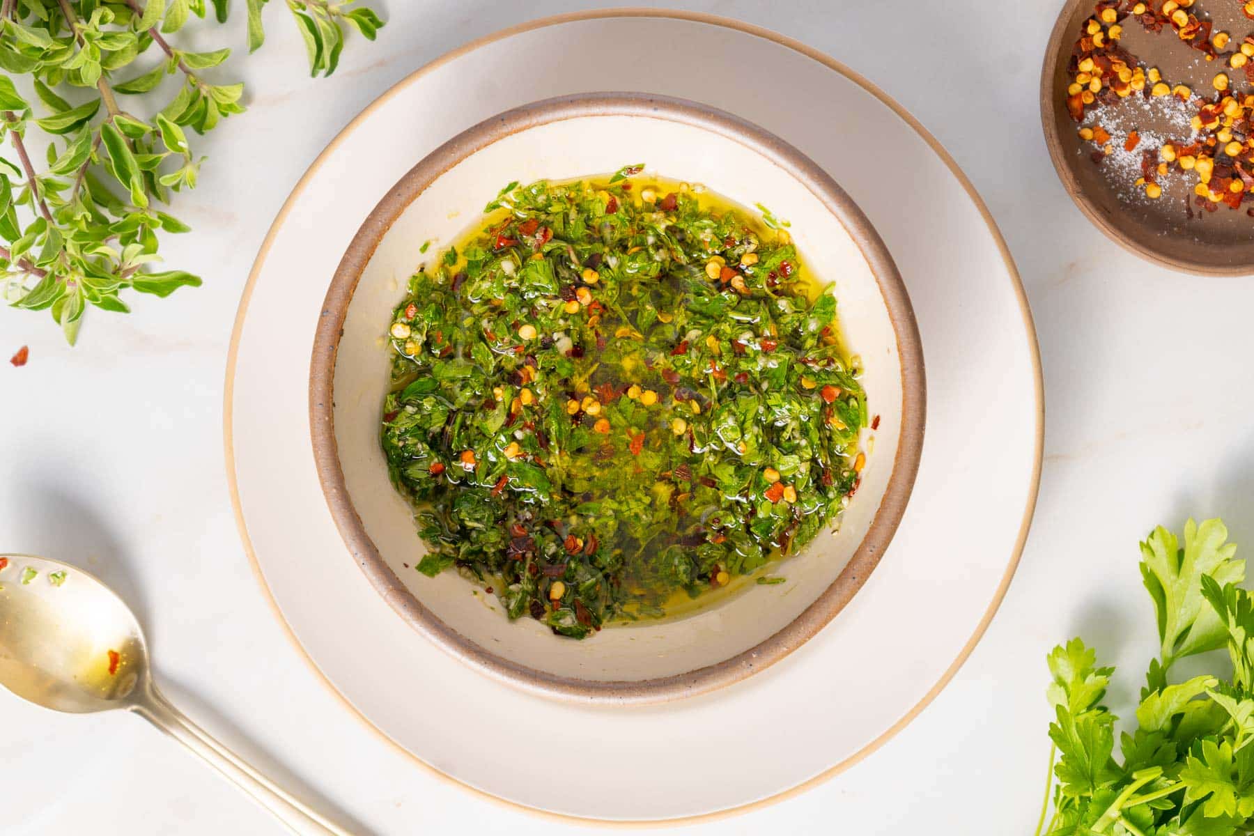 Herbs topped with oil in a bowl.
