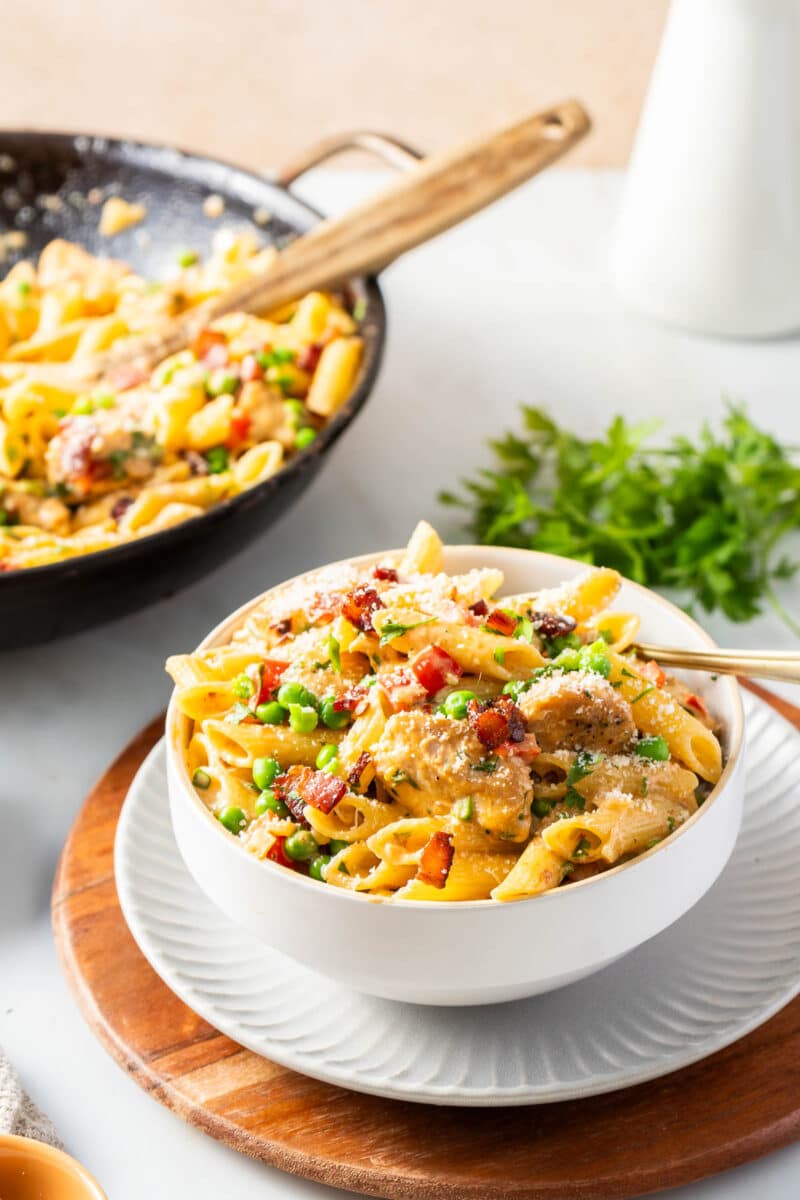 A portion of Chipotle Chicken pasta in a wok and a portion on a bowl.
