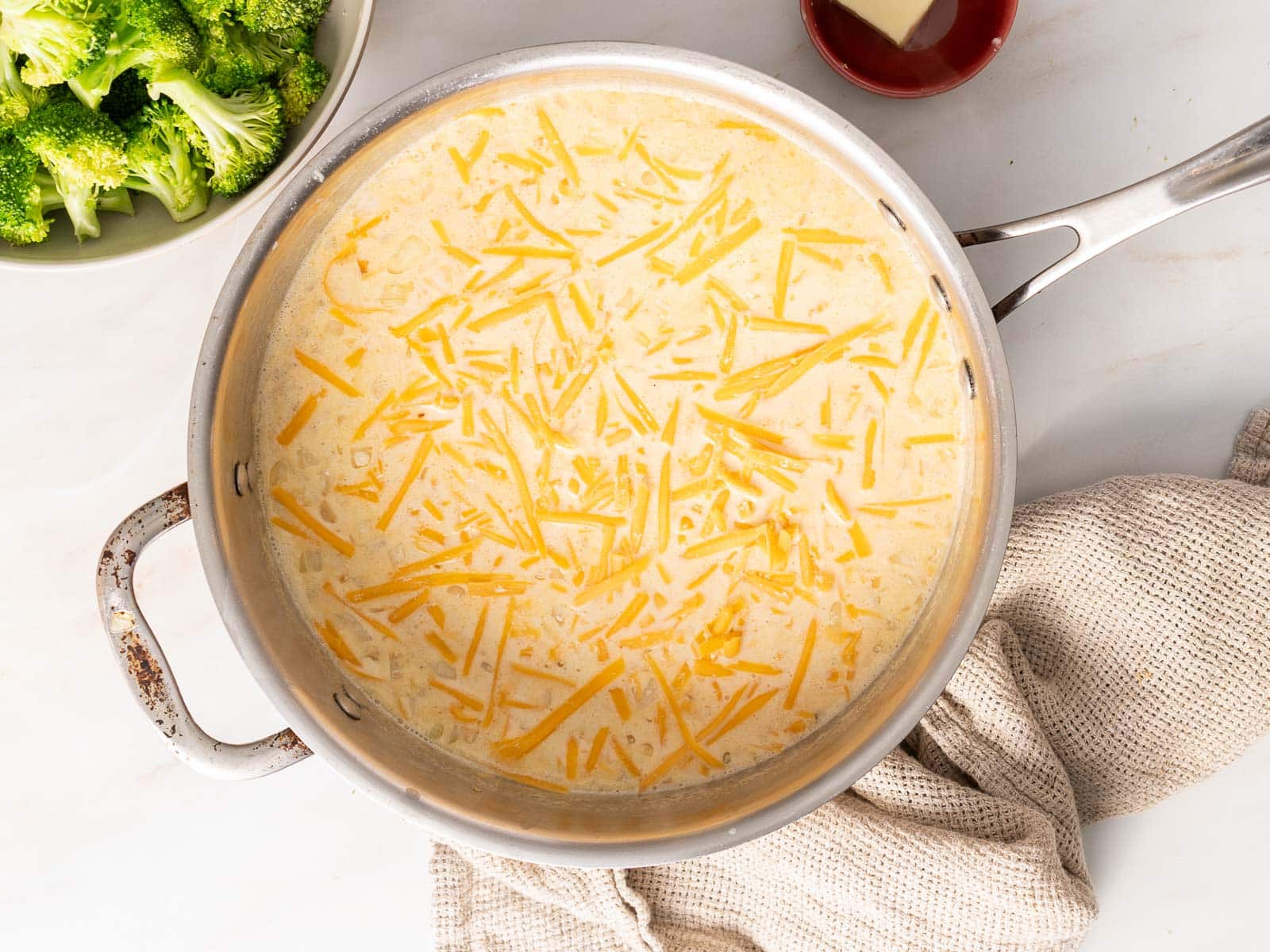 broccoli cheesy and creamy in a sauce pan.