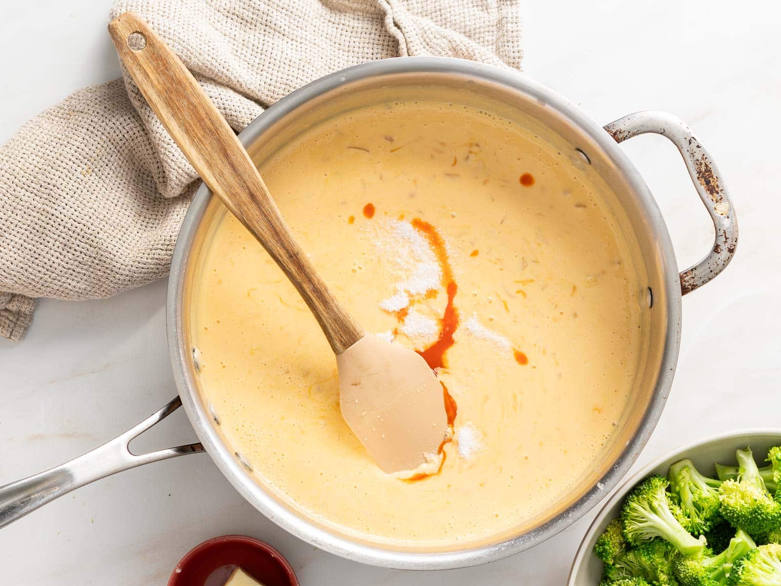 Broccoli Casserole creamy cheesy and creamy sauce on a sauce pan.