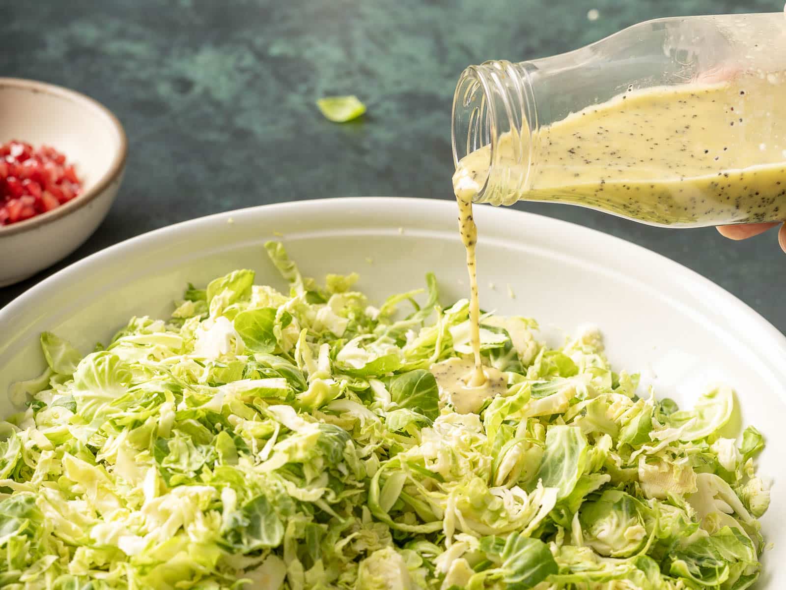 pouring dressing onto brussels sprouts.
