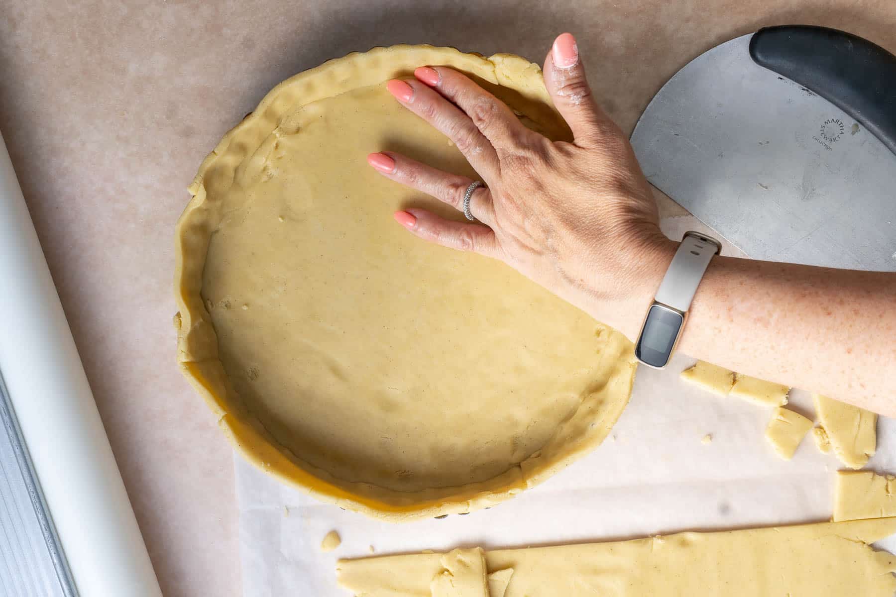 Pressing the dough into the tart shell.