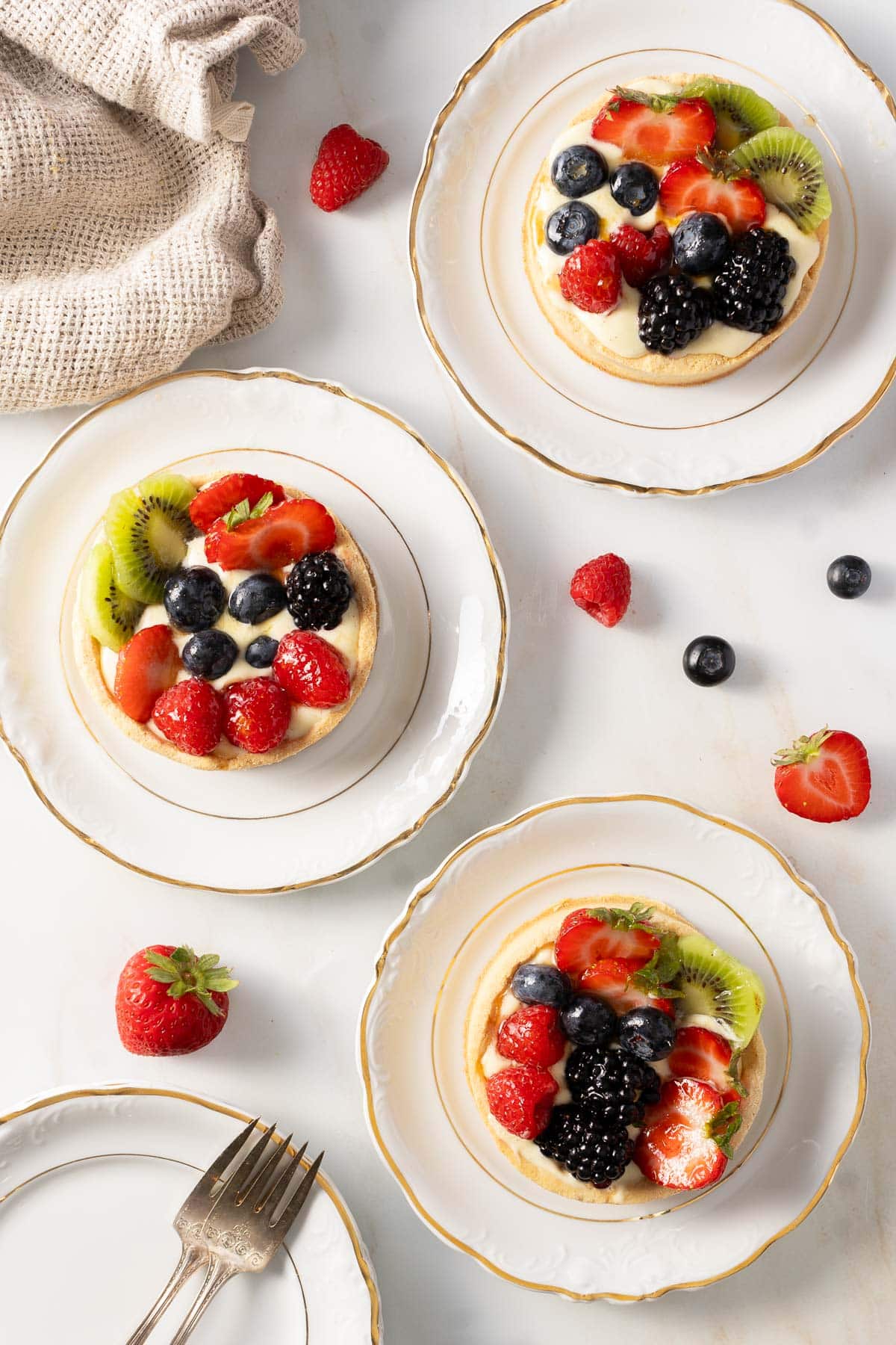 Fruit tarts on china plates.
