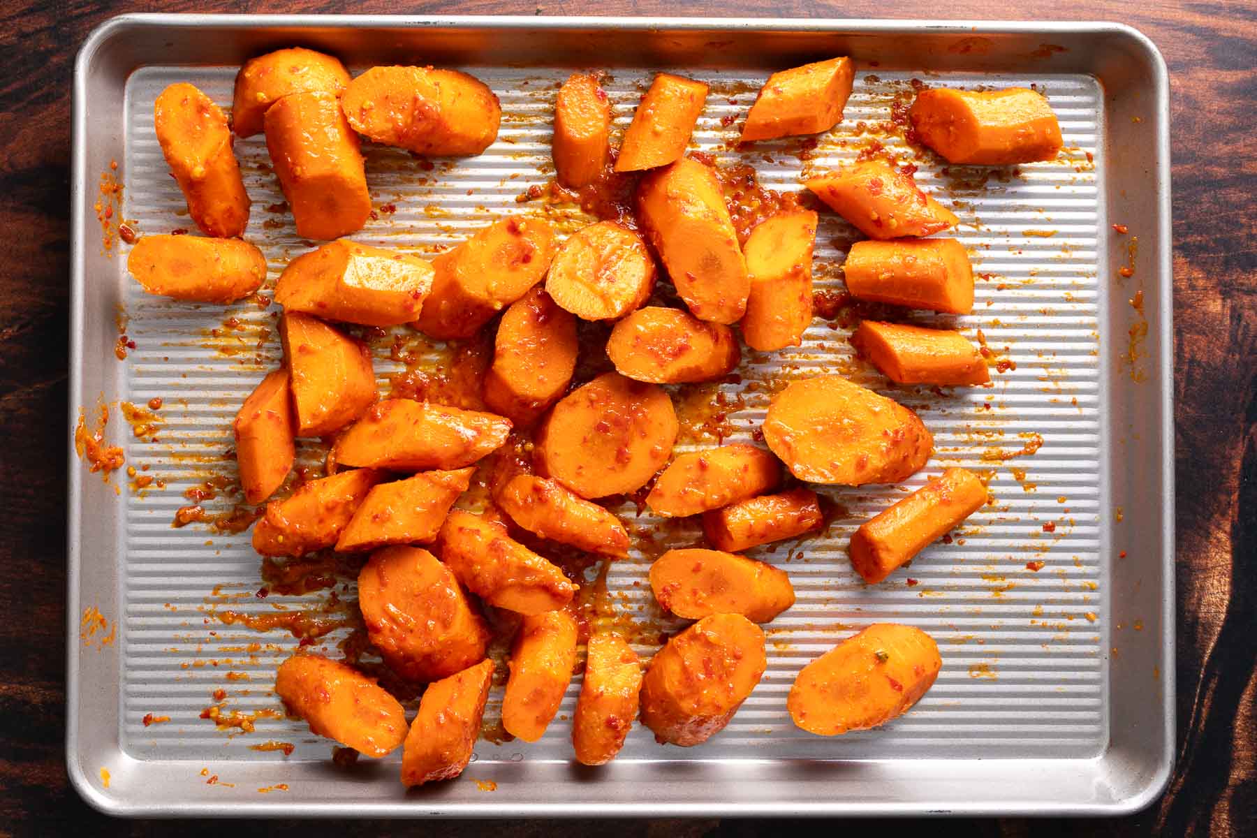 Tossing the carrots in honey and harissa before roasting.