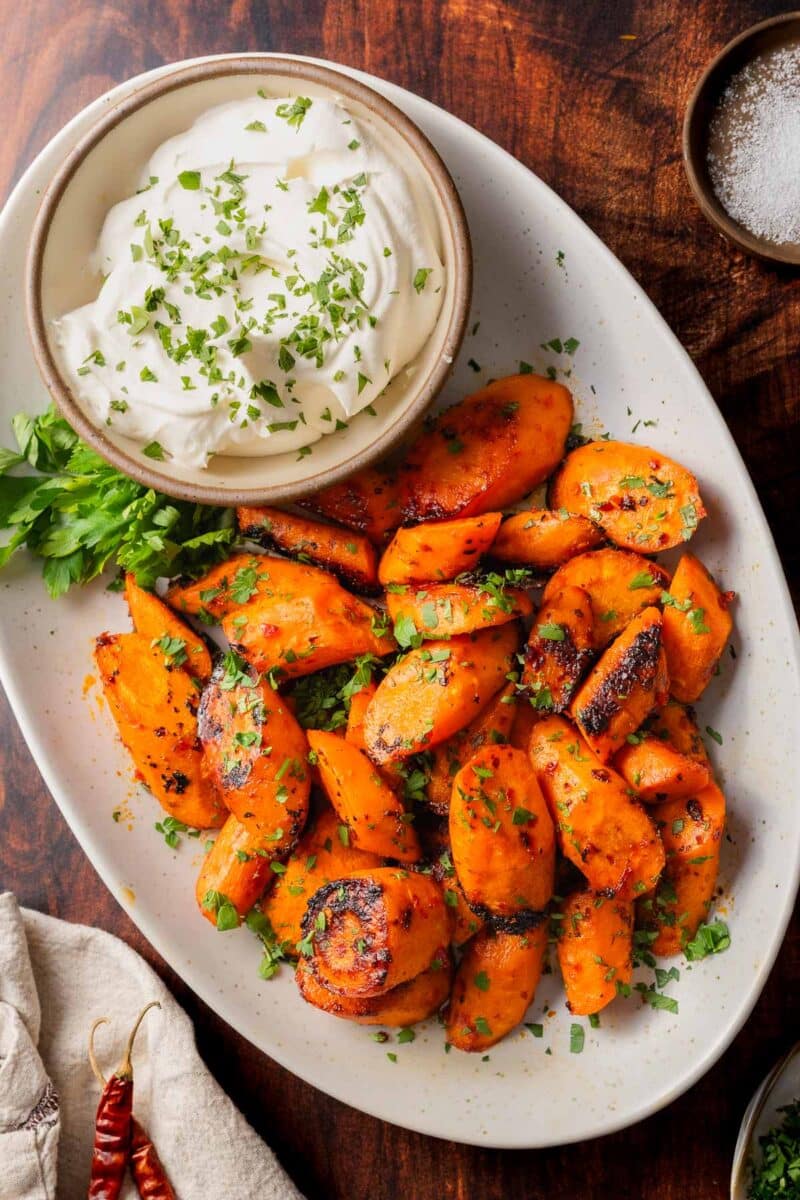 Roasted carrots on a serving platter with feta dip.
