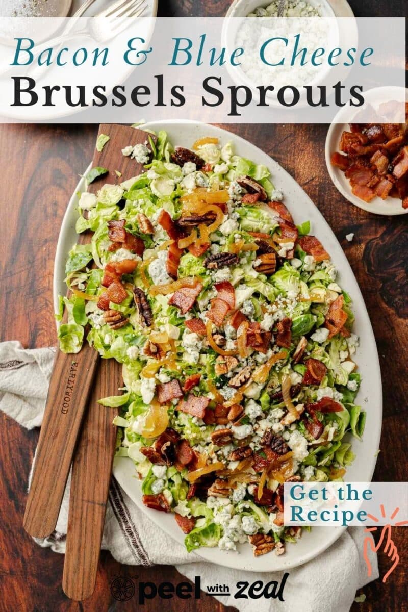 Brussels sprout salad on a cream serving plate with wood tongs.
