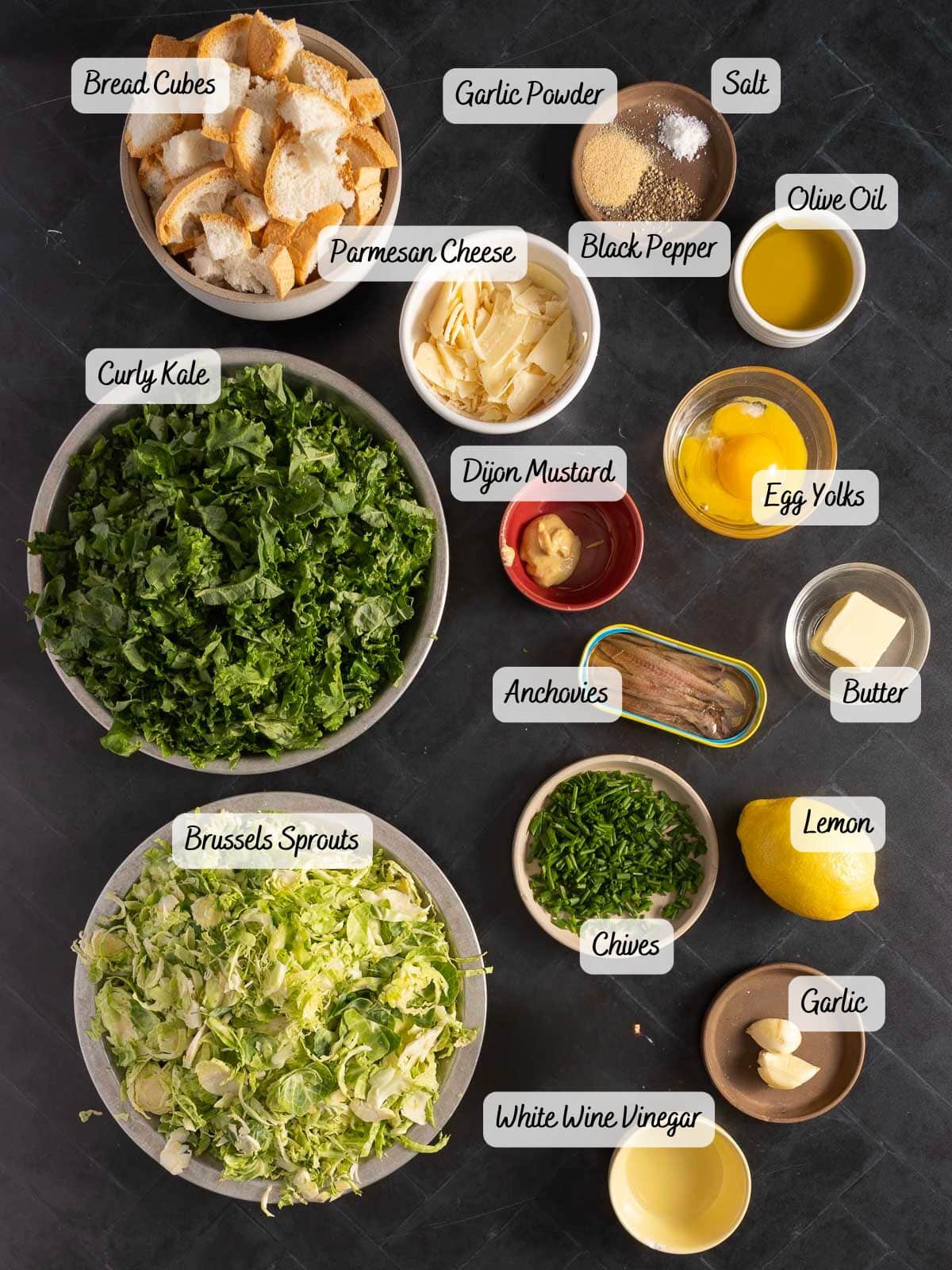 Create a vibrant Caesar Salad with crunchy bread cubes, grated parmesan, curly kale, and tender Brussels sprouts. Infused with garlic powder and mustard, this dish is elevated by anchovies, fresh chives, creamy egg yolks, and rich butter seasoned to perfection.